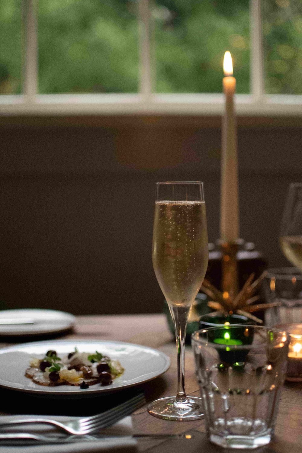 A glass of champagne beside a lit candle
