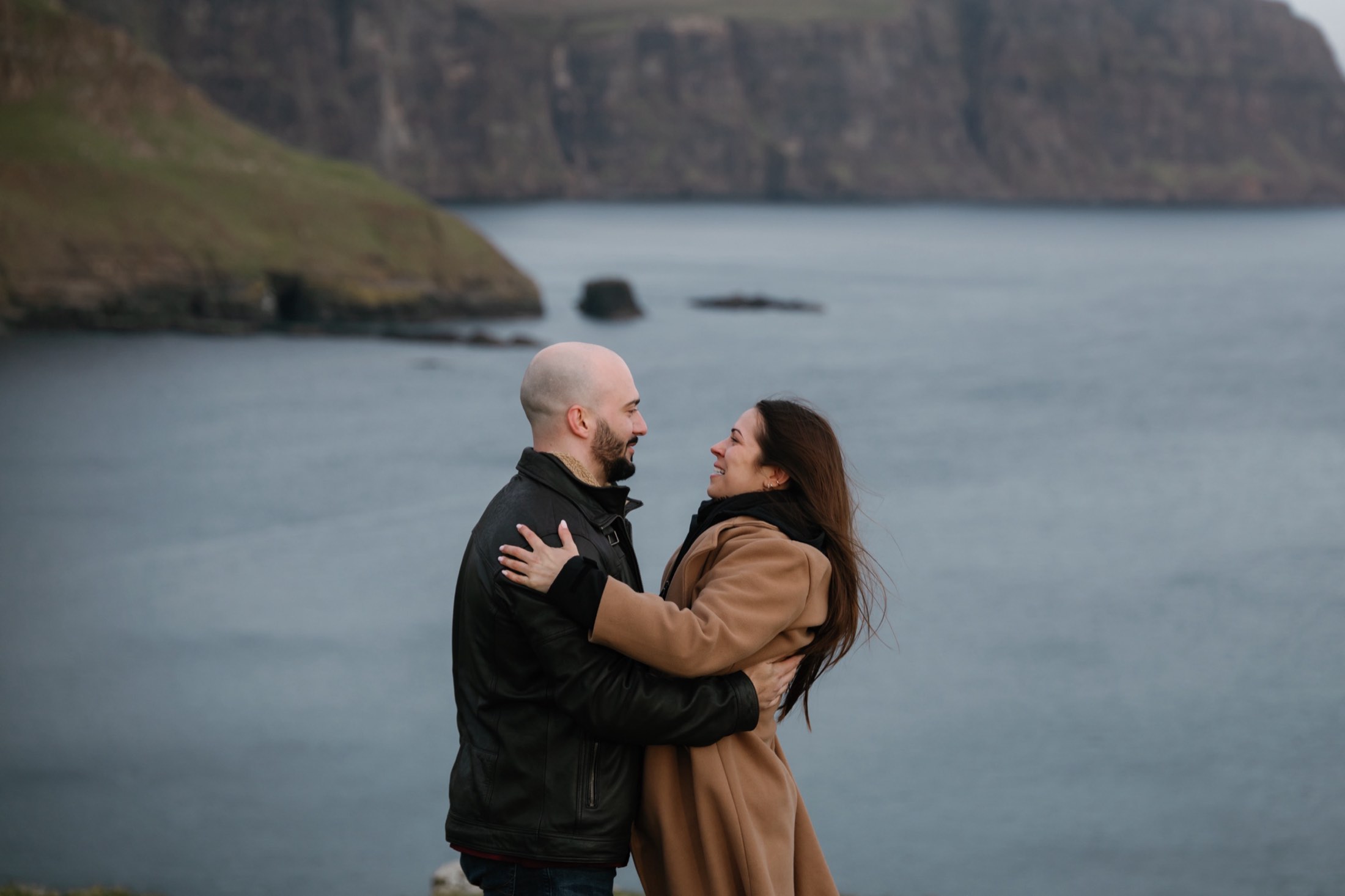 Holding each other with the cliffs behind them
