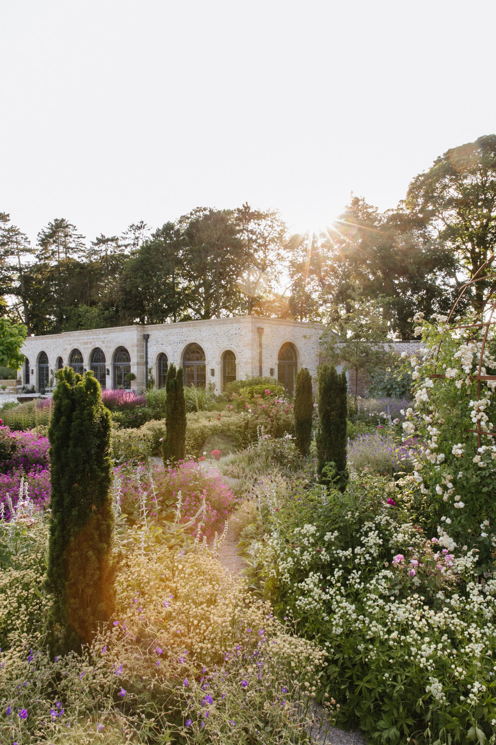The walled garden in evening light, borders in front of the Fig House arcade