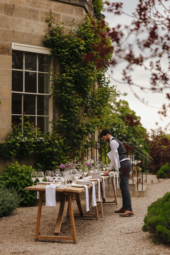 Long tables being laid outside the house in the evening light